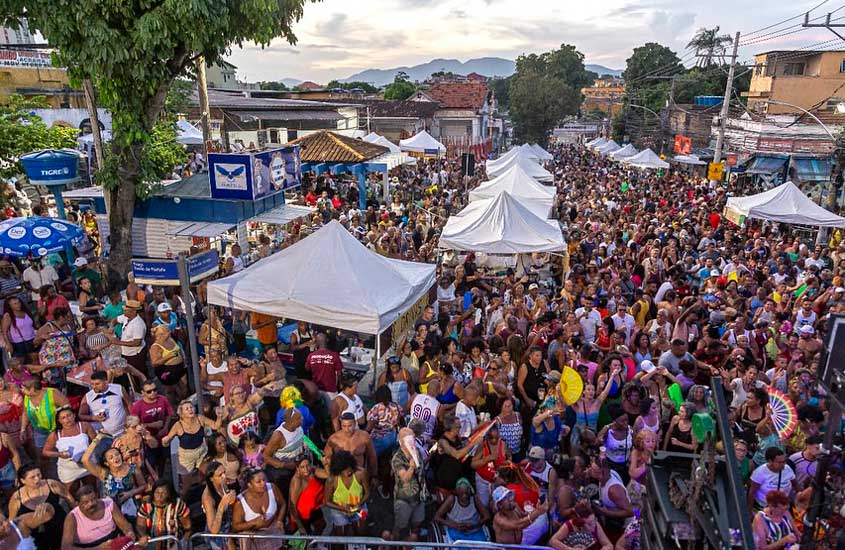 Multidão reunida na Feira das Yabás, em Madureira, Rio de Janeiro, com barracas de comida e música ao ar livre, em um ambiente festivo de celebração cultural.