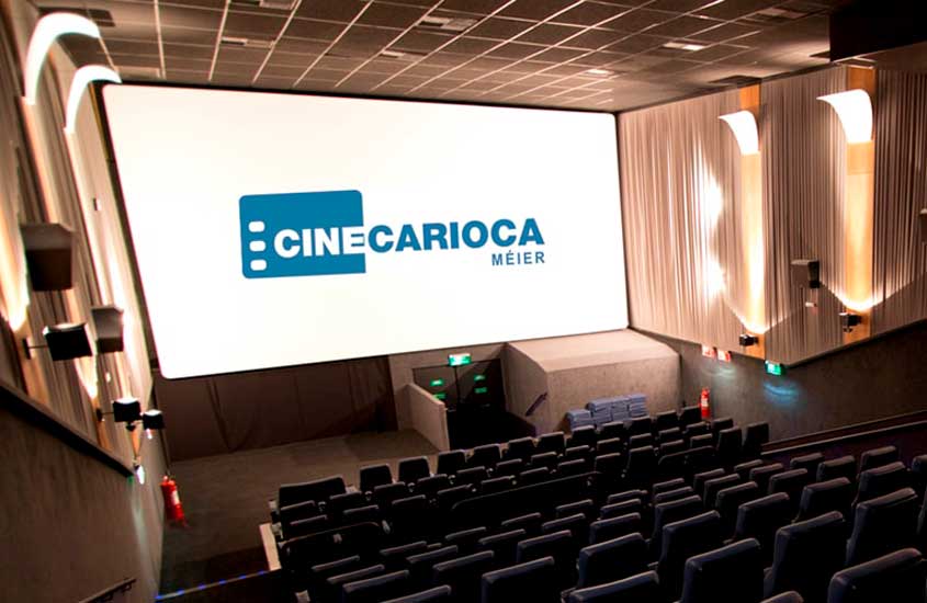Sala de cinema moderna do CineCarioca Méier, com poltronas azuis, iluminação lateral e tela grande ao fundo.