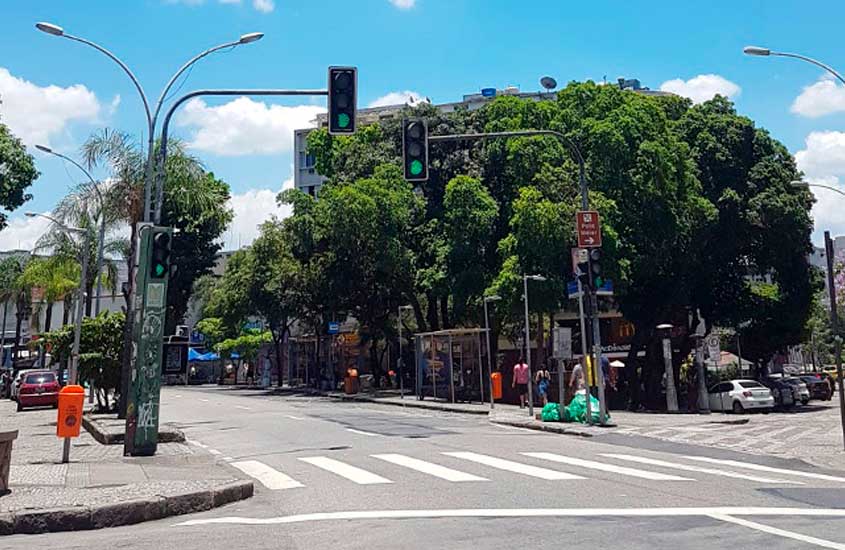 Cruzamento de ruas no Méier, Zona Norte do Rio de Janeiro, com semáforos, faixa de pedestres, ponto de ônibus e o monumento do relógio laranja na Praça Agripino Grieco.